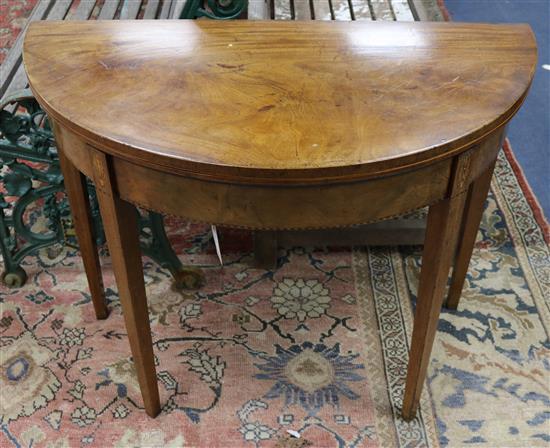 A George III mahogany demi-lune folding top tea table W.92cm